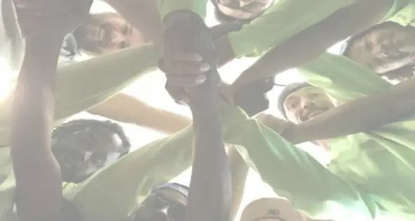 CEP crew in lime green shirts in a hands-in huddle